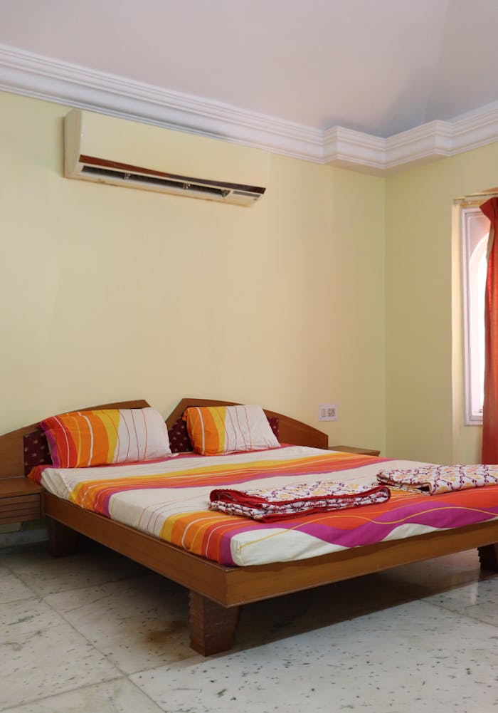 Crafting Captivating Headlines: Your awesome post title goes here A cozy bedroom in Ahmedabad featuring a double bed with vibrant bedding.